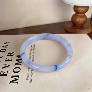 Detailed macro view of a lavender chalcedony bangle placed on a stylish vintage book