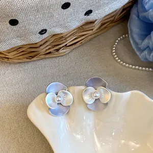 Nahaufnahme von eleganten Perlen-Blumenohrsteckern mit silbernem Nadel-Design