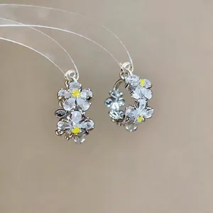 Elegant silver-tone flower hoop earrings with sparkling white zircons and yellow centers.