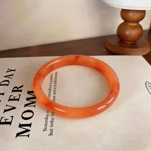 Close-up detail of elegant orange chalcedony bangle with unique natural marbling texture