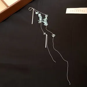 Elegantes Detail langer silberner Quastenohrringe mit hellblauen Schmucksteinen