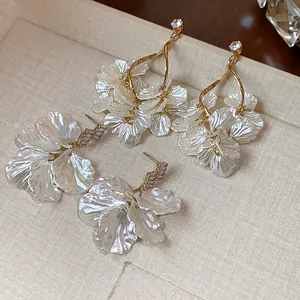 Detailed view of elegant shell-like floral petal earrings with sparkling zircon accents