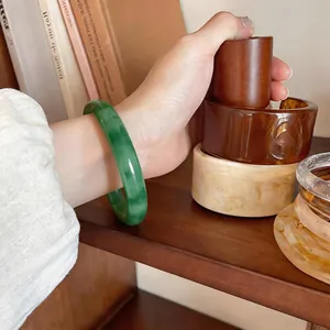 Close-up of a vibrant green chalcedony bangle on wrist in a lifestyle setting