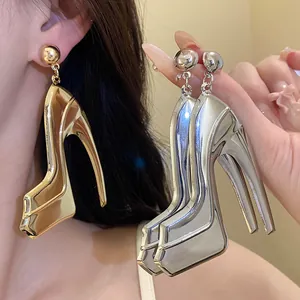 Close-up of metallic high-heel shoe earrings showing the polished gold and silver texture