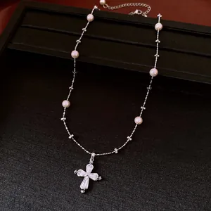 Dettaglio della collana di perle d'argento con ciondolo a croce in zircone