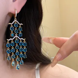 Detailaufnahme eleganter Kronleuchter-Ohrringe mit blauen Zirkonia-Tropfenquasten.