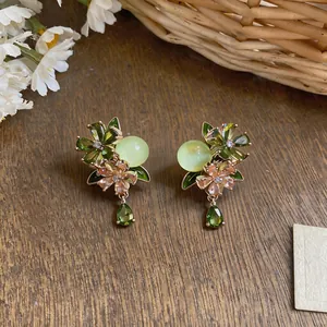 Detailed macro view of elegant green zircon flower earrings with teardrop pendants