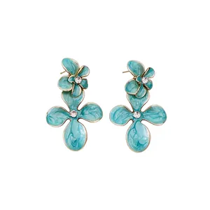 Boucles d'oreilles fleurs vintage avec émail turquoise et centres en cristal brillant.