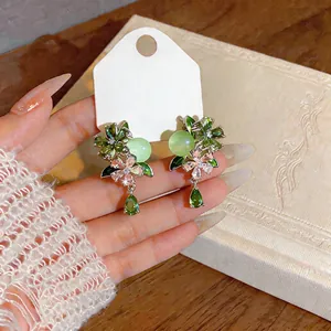 Detail of floral earrings with green zircon water drop pendant and silver needles
