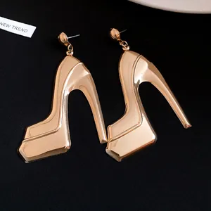 Close-up of elegant gold metallic high heel drop earrings with a glossy mirror finish