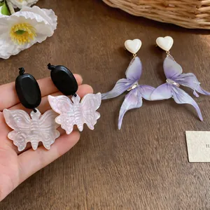 Vue détaillée de boucles d'oreilles vintage en bois et résine aux papillons violets