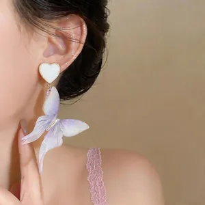 Gros plan de boucles d'oreilles papillon vintage en résine violette avec clous en coeur