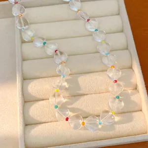 Close-up of transparent heart-shaped crystal beads with colorful accent spacers.