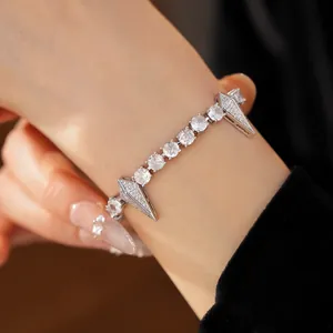 Elegant zircon bracelet with round stones and spiked charms for a punk-luxury look.
