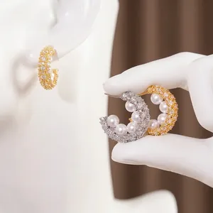 Elegant C-shaped pearl earrings with sparkling zircon pave finish in silver and gold