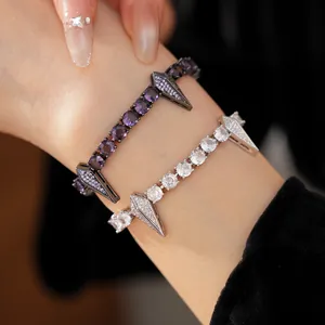 Close-up detail of punk style zircon bracelets with round stones and rhombus studs.