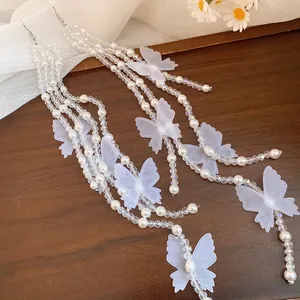 Detailed view of beaded pearl tassel earrings with delicate white chiffon butterflies.