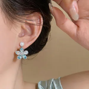 Exquisite blue crystal flower pendant earrings with pearl studs shown on ear detail