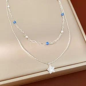 Detailed view of silver double-layer necklace with star pendant and blue crystal beads