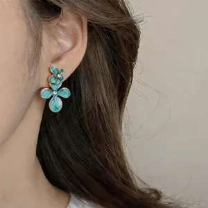 Vue détaillée de boucles d'oreilles fleurs en émail bleu vintage avec cristal serti