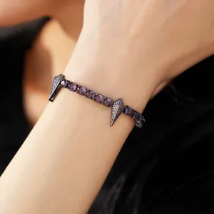 Close-up of hip-hop punk style bracelet with purple cubic zirconia and diamond pendants