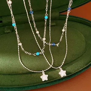 Close-up of a double-layer beaded necklace featuring shimmering zircon star pendants on velvet