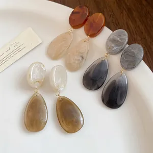 Vue détaillée de boucles d'oreilles élégantes en résine avec motif marbré lisse