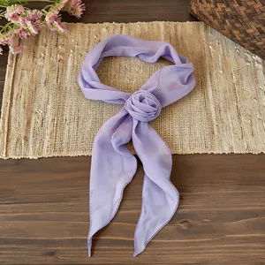 Macro detail of elegant purple chiffon scarf featuring a delicate handmade flower rose