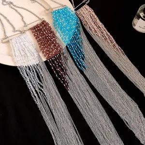 Gros plan de colliers à pompons multicolores avec pendentifs de style épingle.