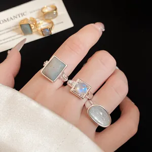 Detailed close-up of 18k gold plated open rings featuring square and oval stones