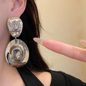 Dettaglio degli orecchini pendenti vintage in metallo argento con cappello da cowboy