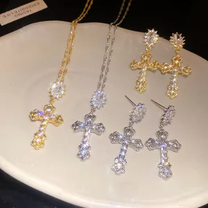 Detailed view of 18k gold plated zircon cross necklaces and matching earrings