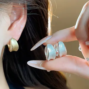 Detailed macro view of brushed gold and silver minimalist hoop earrings for women