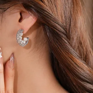 Elegant C-shaped silver stud earrings with sparkling cubic zirconia and white pearls.