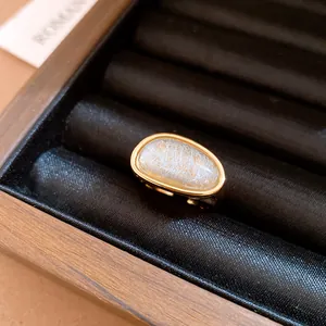 Close-up of a minimalist 18k gold plated open ring with a rutilated quartz stone