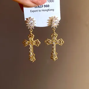 Close-up of 18k gold-plated cross earrings with brilliant zircon stones.