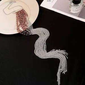 Vue détaillée d'un collier à pampilles en chaîne argentée avec des accents de perles brunes.