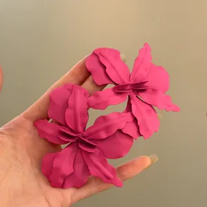 Detailed macro shot of oversized hot pink matte flower earrings for beach vacation