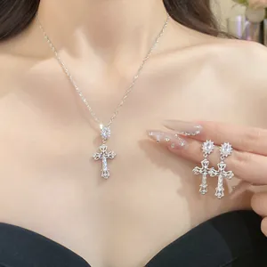 Elegant 18k gold plated cross pendant necklace and earrings set worn by a model