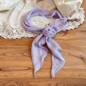 Lavender chiffon scarf with a fabric rose detail shown on a warm wooden background.