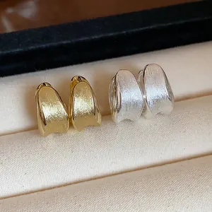 Detailed view of elegant brushed metal hoop earrings in gold and silver plated finish