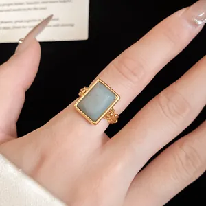 Close-up detail of a 18k gold plated open ring featuring a rectangular light grey stone