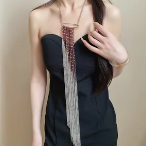 Vue détaillée d'un collier à pompon long avec épingle de sûreté et perles brunes
