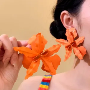 Oversized orange flower stud earrings for women, vibrant beach holiday style detail