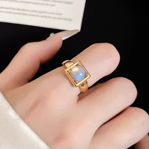 Close-up view of a gold-plated square open ring featuring a round moonstone gemstone.