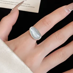 Close-up detail of a minimalist 18k gold plated ring featuring a light blue stone