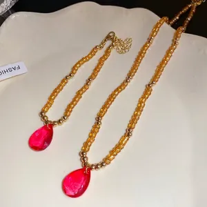 Collana vintage di perle di vetro con ciondolo a goccia rosso e perline ambrate