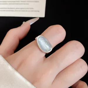 Close-up of 18k gold-plated open ring with an elegant oval light blue stone