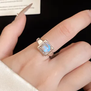 Close-up of elegant square moonstone open ring with blue flash on finger