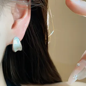 Detailed view of a silver brushed metal ear buckle on an ear for a minimalist look